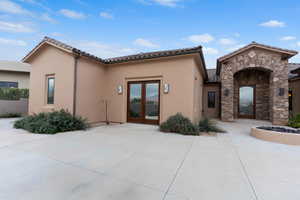 View of front of home featuring french doors, stucco siding, stone siding, and a tile roof