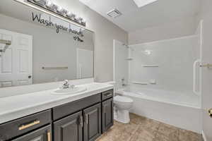 Full bathroom with vanity, bathtub / shower combination, and a skylight