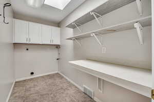 Laundry area featuring cabinet space, a skylight, and electric dryer hookup