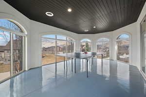 Game room featuring a mountain view, concrete flooring, wood ceiling, and recessed lighting
