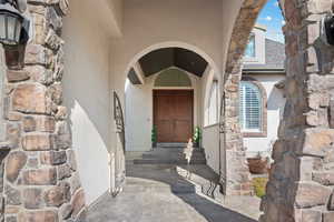 View of exterior entry featuring stucco siding and stone siding