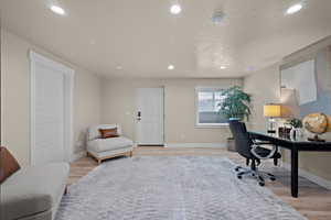 Office space with recessed lighting, light wood finished floors, and a textured ceiling