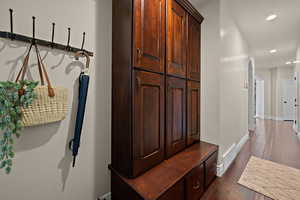 Mudroom featuring arched walkways, recessed lighting, and dark wood finished floors