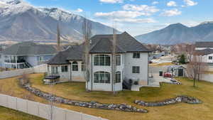 Rear view of house with a fenced backyard, stucco siding, a mountain view, and a patio area
