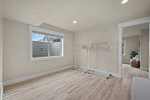 Empty room with light wood-style flooring and recessed lighting