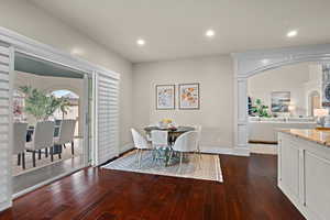 Dining space with dark wood finished floors and recessed lighting