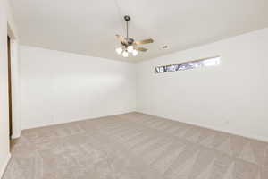 Empty room featuring light carpet and a ceiling fan