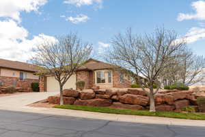 Ranch-style home with driveway, an attached garage, and brick siding