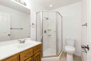 Full bath featuring a shower stall, vanity, and light tile patterned floors