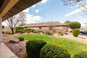View of home's exterior with brick siding and a yard