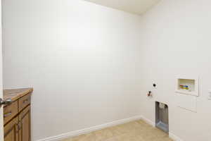 Laundry room featuring hookup for a washing machine, light tile patterned floors, hookup for a gas dryer, and electric dryer hookup