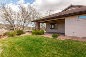 View of grassy yard with a patio area