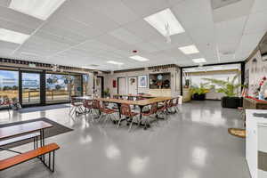 Dining room featuring concrete floors and a drop ceiling