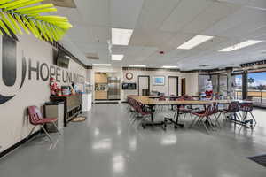 Dining space featuring finished concrete floors and a drop ceiling