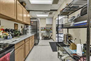 Kitchen with stainless steel appliances, light countertops, and a paneled ceiling