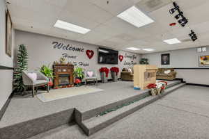 Rec room with a glass covered fireplace and a paneled ceiling