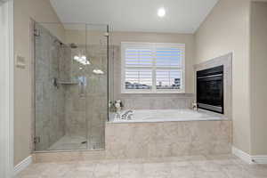 Primary bath features a shower, jetted tub, and fireplace.