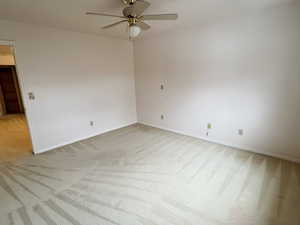 Spare room with a ceiling fan and light colored carpet