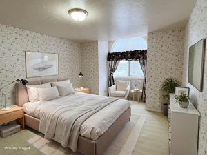 Bedroom featuring wallpapered walls and a textured ceiling