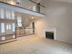 2-story living room with a high end fireplace, and recessed lighting