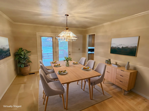 Dining room featuring hanging lights and ornamental molding