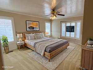 Bedroom featuring light carpet, ceiling fan, and ornamental molding