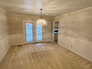 Dining area featuring light carpet, hanging lights, and crown molding