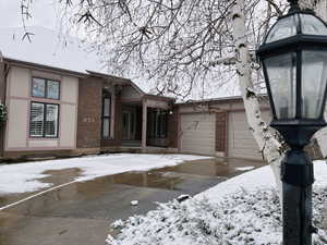 View of front of property featuring brick siding, a garage, and concrete driveway