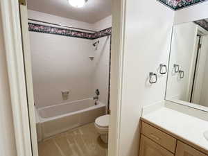 Bathroom featuring vanity, a textured ceiling, shower / tub combination, and light tile patterned floors
