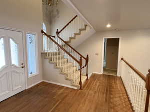 Foyer entrance with dark wood-type flooring and a chandelier