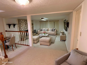 Carpeted living room with a textured ceiling
