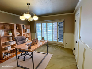 Office area with crown molding, hanging lights, and wainscoting