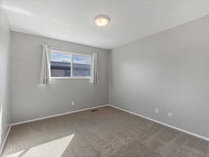 Unfurnished room with light colored carpet and baseboards