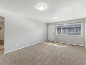 Carpeted spare room with baseboards