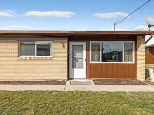 View of front of property featuring a front lawn and brick siding