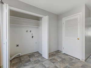 Laundry area with stone finish floors, hookup for an electric dryer, and hookup for a washing machine