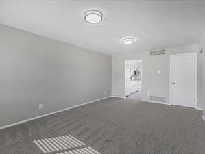 Empty room featuring dark carpet