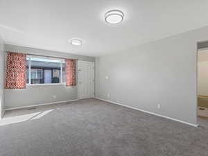 Spare room with baseboards and carpet flooring