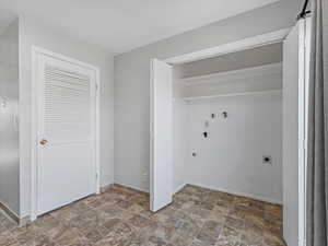 Laundry area featuring stone finish flooring, washer hookup, and electric dryer hookup