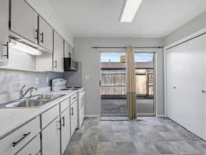 Kitchen featuring electric stove, light countertops, and stone finish flooring