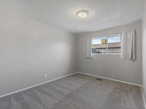 Carpeted empty room featuring baseboards
