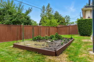 Fenced backyard with a vegetable garden
