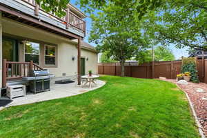 Fenced backyard with a patio and a balcony