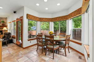Dining space with a fireplace, light tile patterned floors, and recessed lighting