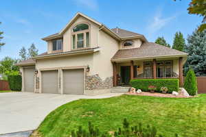 View of front facade featuring stucco siding, driveway, an attached garage, and roof with shingles