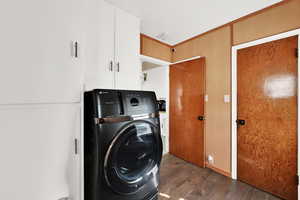 Laundry area with washer / dryer and dark wood-style floors