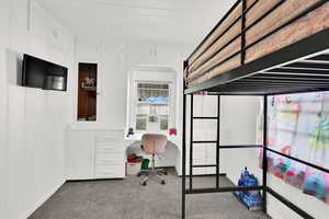 Bedroom featuring carpet floors and built in desk