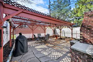 Fenced backyard featuring outdoor dining space, grilling area, a pergola, and a patio