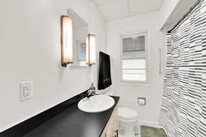 Bathroom with a drop ceiling, vanity, and a shower with curtain