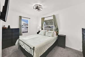 Bedroom featuring dark carpet and baseboards